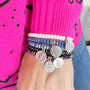 A stack of harper saint bracelets on a hand