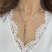 Necklace with a pendant worn by a person in a white lace garment
