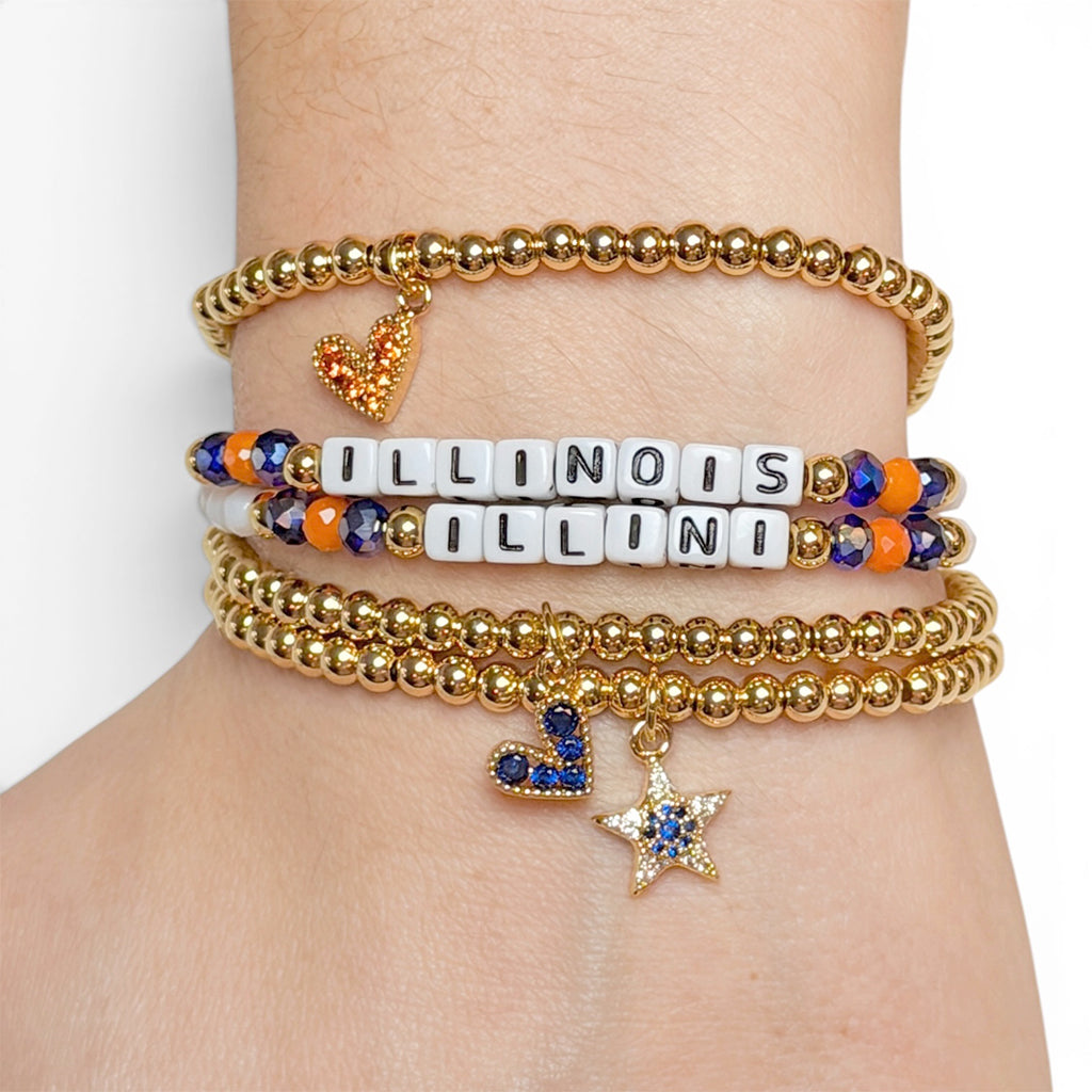 Stack of gold and colorful beaded bracelets on a wrist with 'ILLINOIS' bracelet.