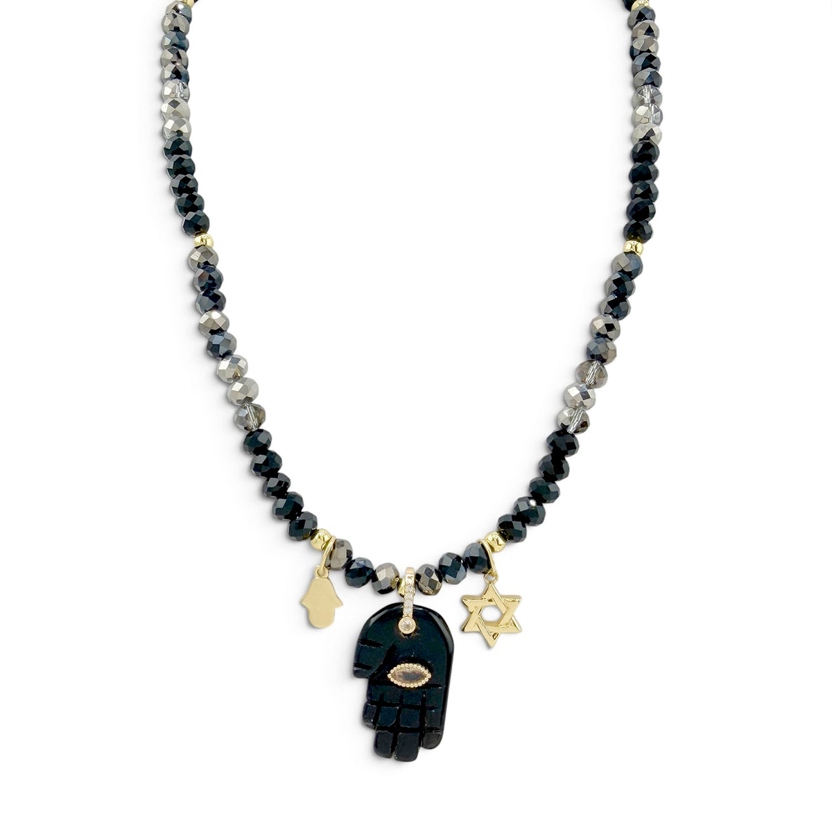 ove Lisa Amalia Gemstone Hamsa Protection Necklace with black and grey rondelle beads, large black gemstone Hamsa pendant, petite gold-tone Hamsa, Star of David charm, and CZ accents on white