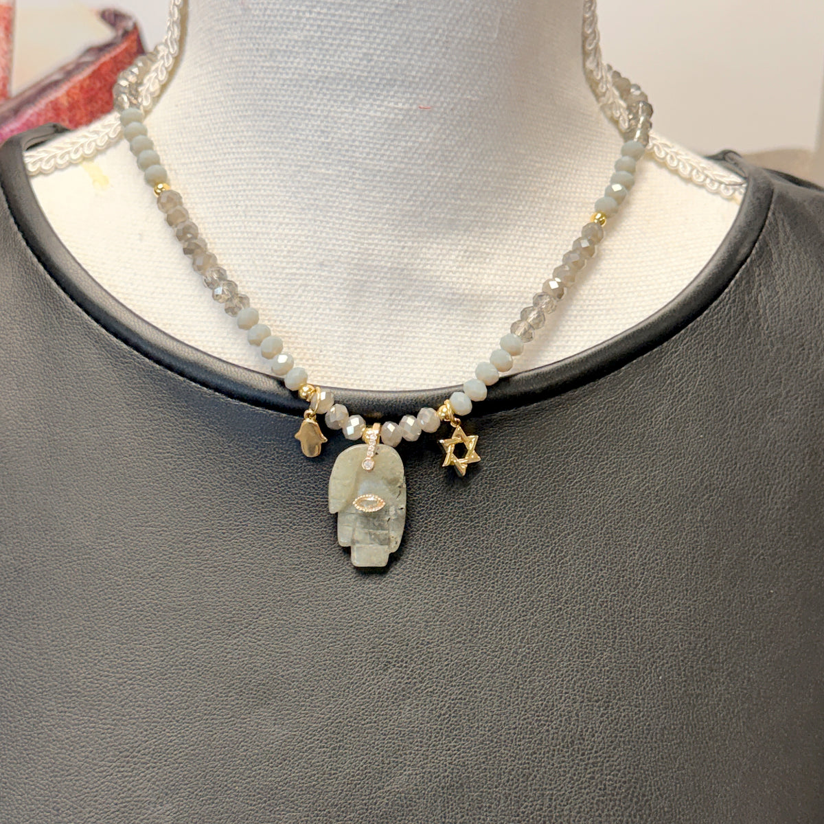 Love Lisa Amalia Gemstone Hamsa Protection Necklace worn at the neckline with a rondelle bead strand, large gemstone Hamsa pendant, petite Hamsa, and Star of David charm