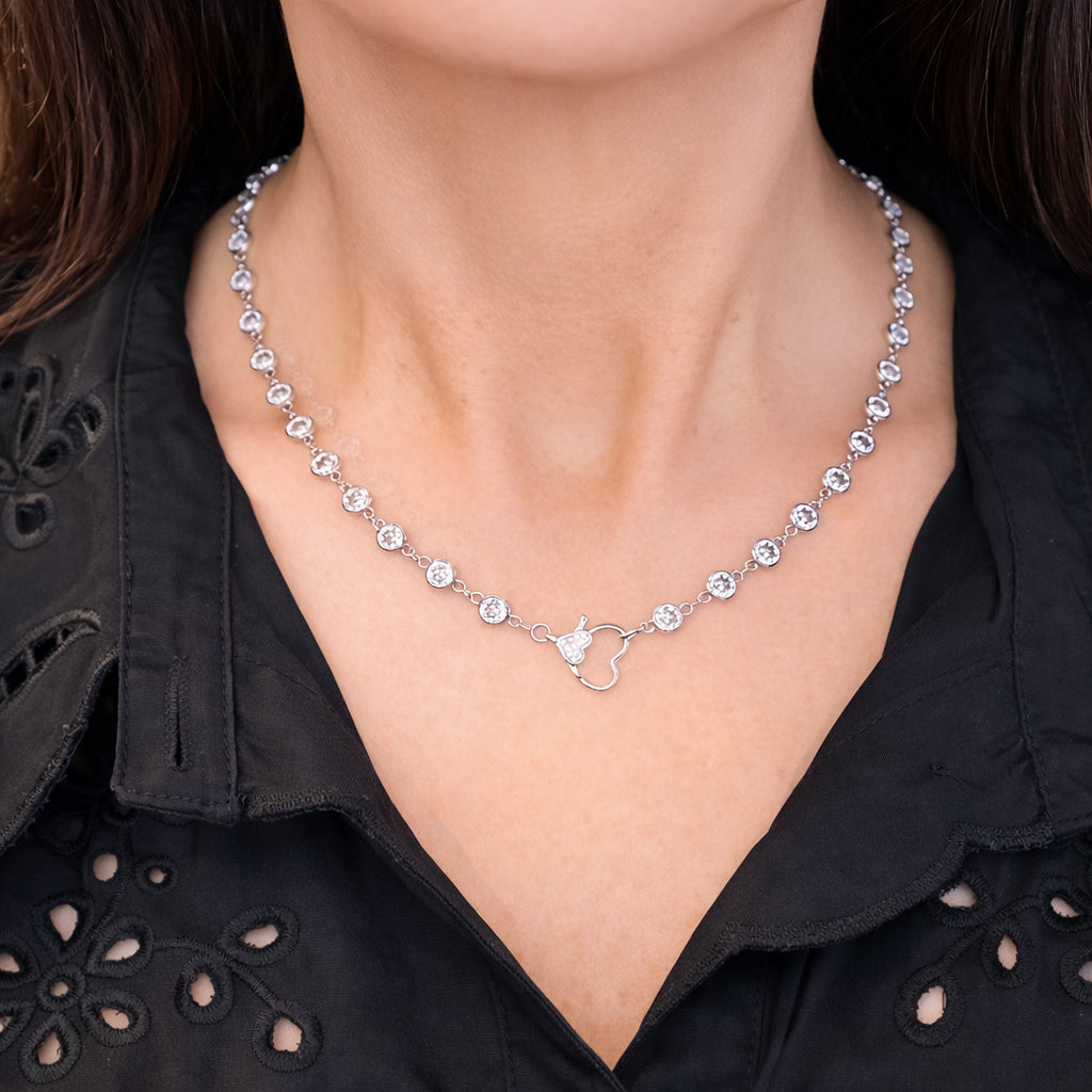 Close-up of Amanda Heart Chain Necklace in silver worn on neck, featuring sparkling crystal stations and heart link detail