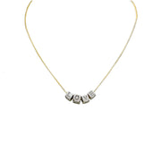 A personalized necklace with gold chain and silver block letter beads.