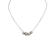 A personalized necklace with gold chain and silver block letter beads.