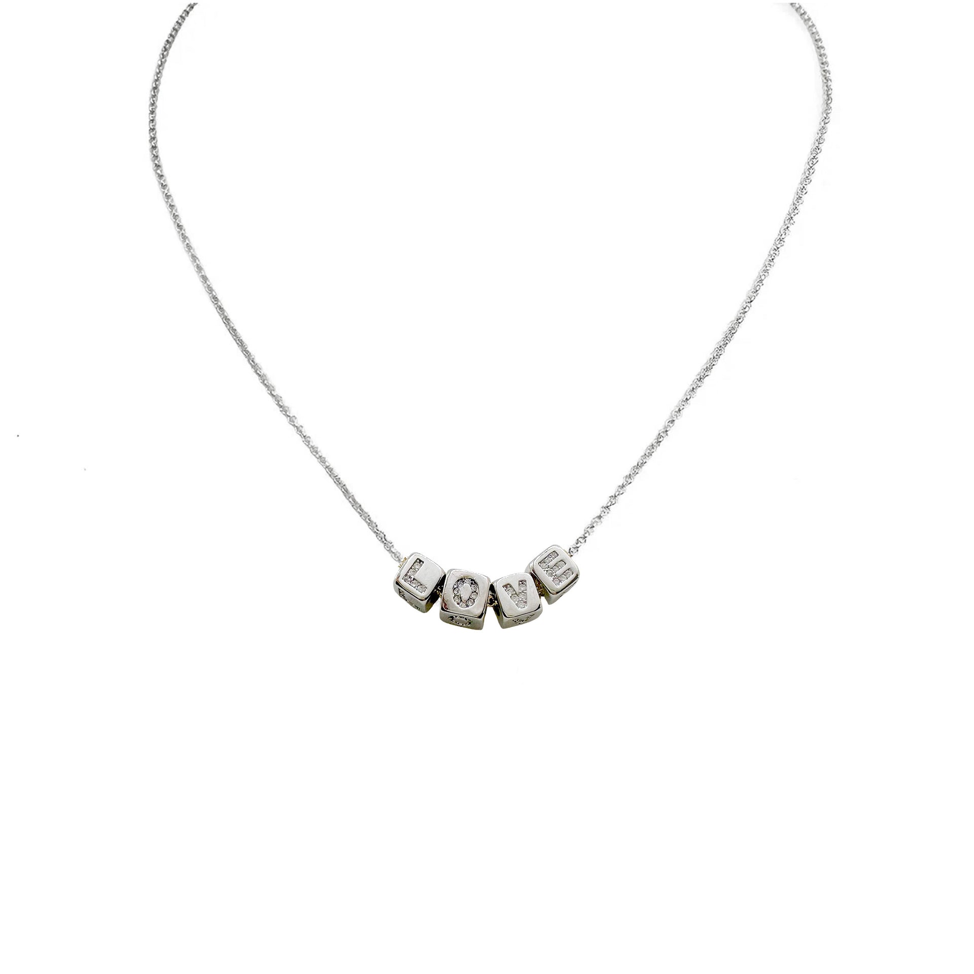 A personalized necklace with gold chain and silver block letter beads.