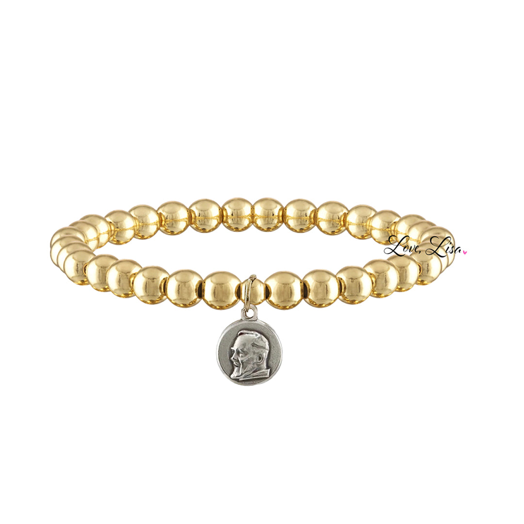 A collection of beaded bracelets with various metallic finishes and Saint medals.