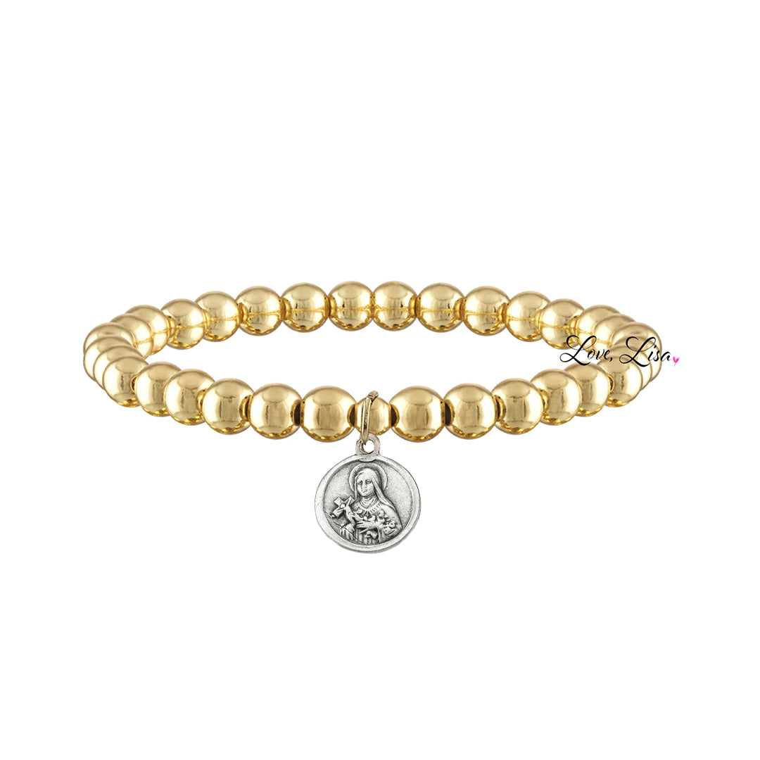 A collection of beaded bracelets with various metallic finishes and Saint medals.