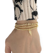arlet angel wing beaded bracelet worn on wrist gold beaded stretch bracelet with cz wing charm by love lisa