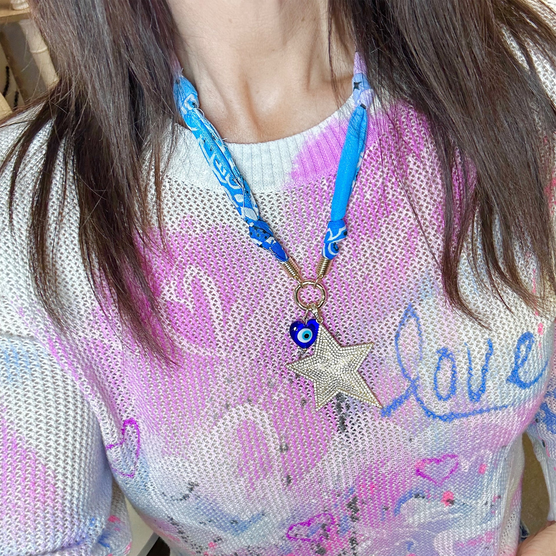 Person wearing a colorful shirt with a star-shaped pendant