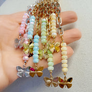 Love Lisa Bailey butterfly drop necklace display showing multiple color options with paperclip chain and cascading bead drops