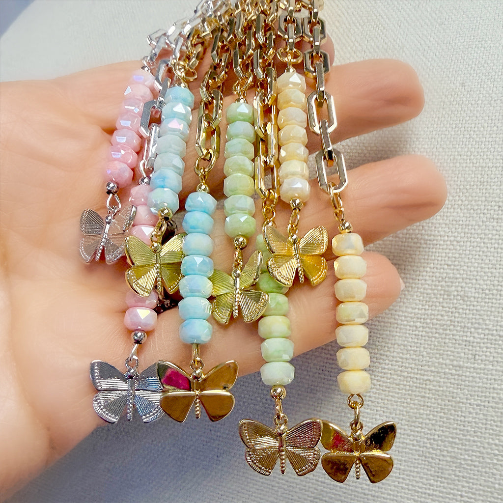 Love Lisa Bailey butterfly drop necklace display showing multiple color options with paperclip chain and cascading bead drops