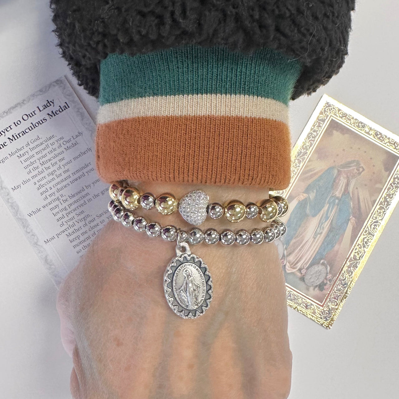 beautiful blessed miraculous beaded bracelet worn on wrist with miraculous medal charm silver stretch bracelet by love lisa
