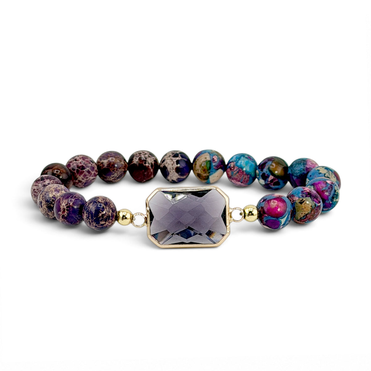 Bellissima Emerald Cut Crystal Gemstone Bracelet in Purple with dark gemstone beads, gold-tone accents, and lavender crystal centerpiece