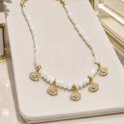 Love Lisa Bianca Mother of Pearl Evil Eye Necklace displayed with white beads and pavé evil eye charm details