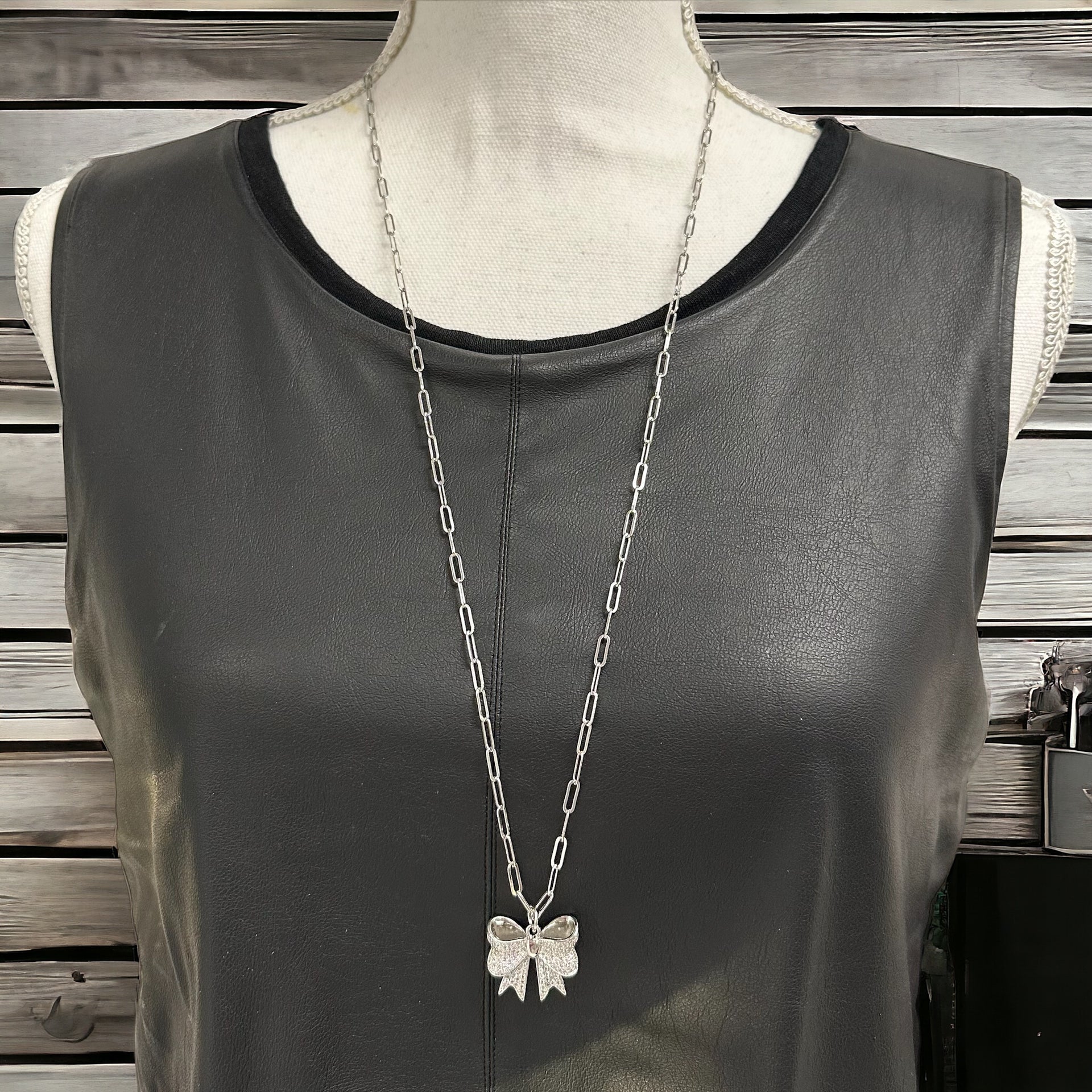 brandy long bow necklace displayed on jewelry stand with cz bow pendant by love lisa jewelry