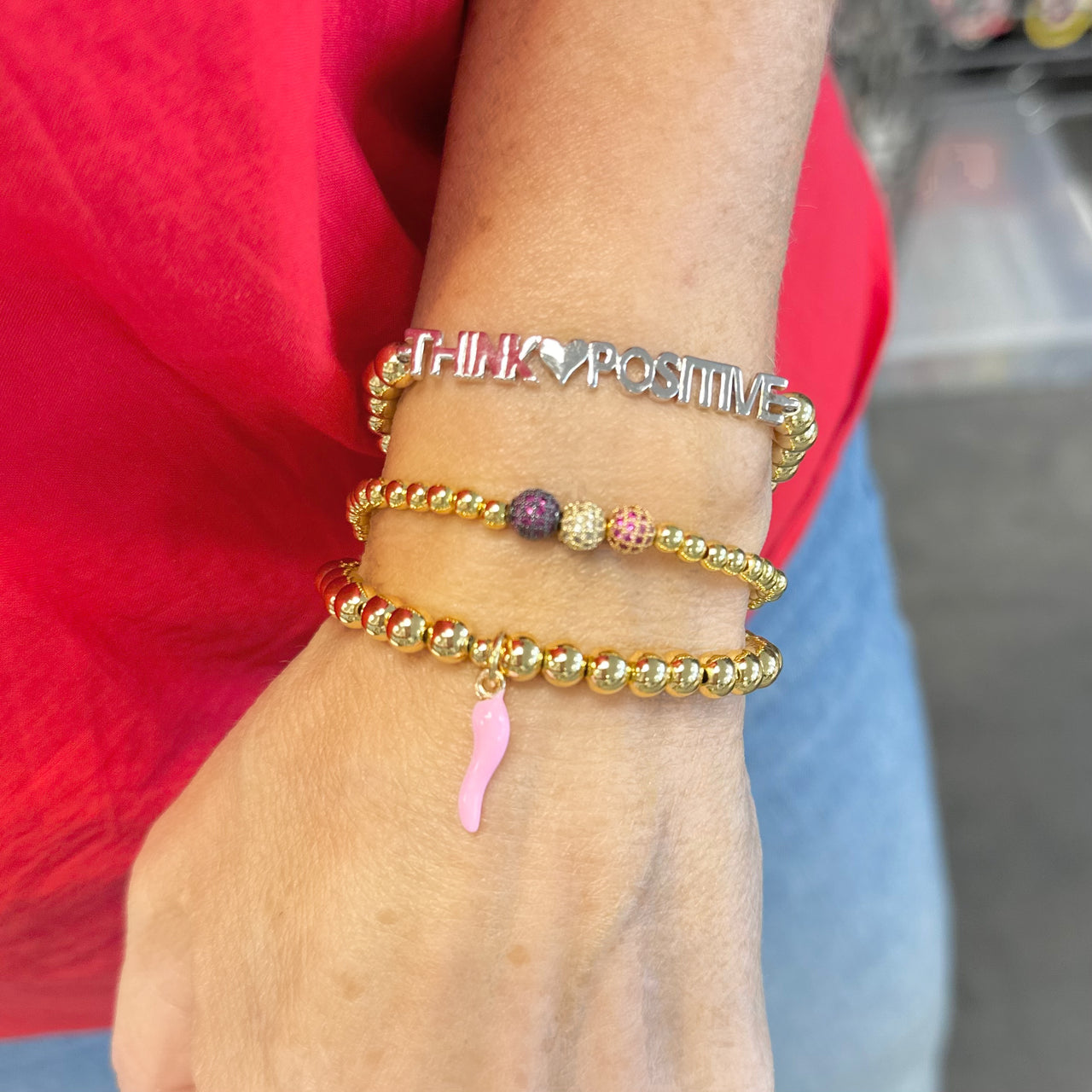 Love Lisa Breast Cancer Awareness Pink Italian Horn Bracelet worn in a bracelet stack with gold-tone beads and pink Italian horn charm