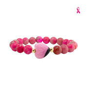 Pink sea sediment jasper worry stone bracelet with smooth heart-shaped focal bead on white background