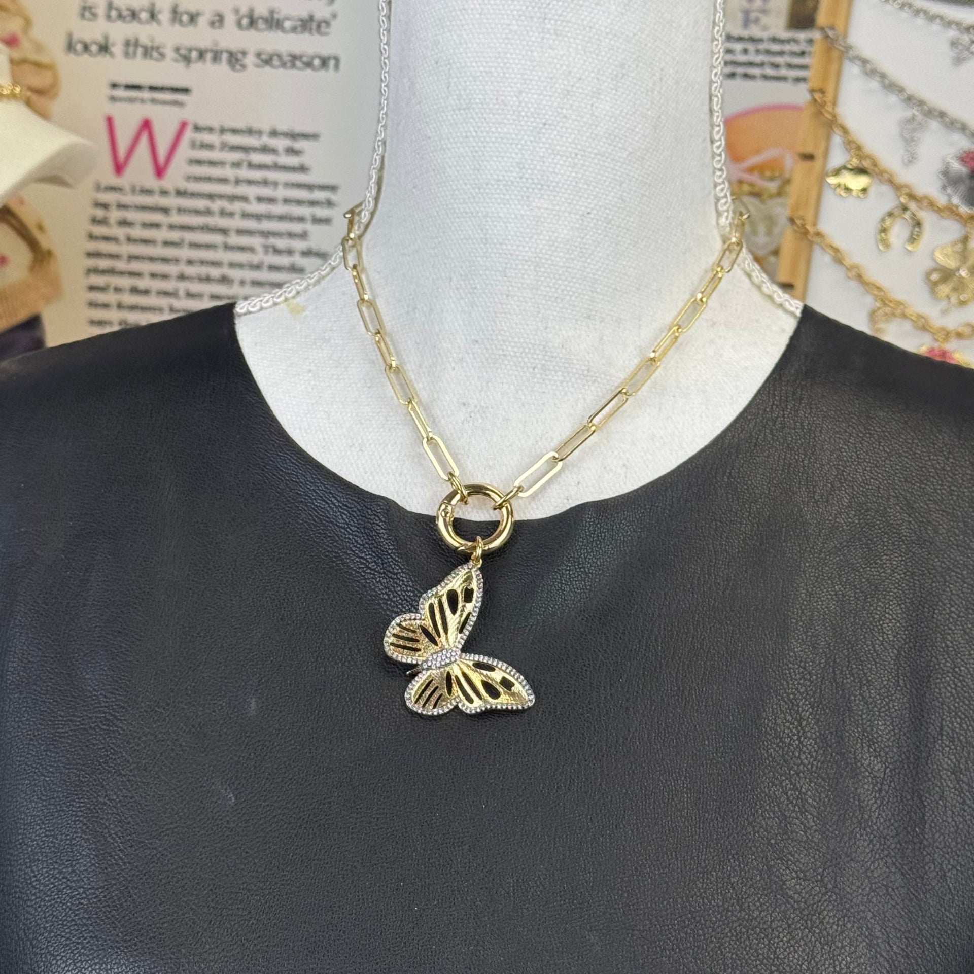 Butterfly jewelry charm with intricate cutout design in gold