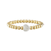 A bracelet with gold beads and a sculpted pearl heart bead in the center, with the signature of the artist on the bottom right.