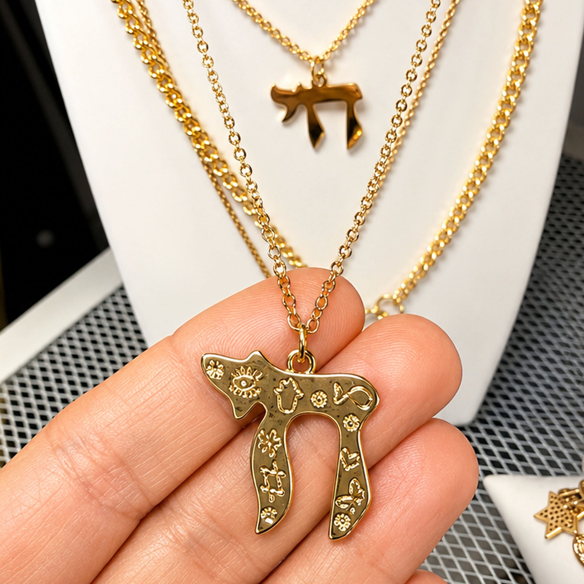 Love Lisa Chai to Life necklace gold pendant detail with engraved evil eye Hamsa Star of David and heart symbols