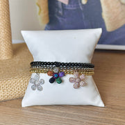 Charlotte Flower Charm Bracelet with crystal flower charm on stretch beaded bracelet in black, gold, and silver