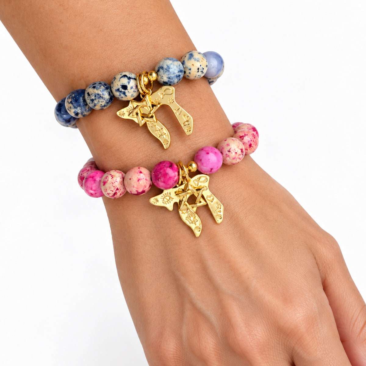 Love Lisa Chaya Chai & Star of David Gemstone Bracelets worn on wrist in navy and pink fossil gemstone styles with gold-tone Judaica charms