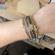 christine cross bracelet stacked on wrist with beaded styles