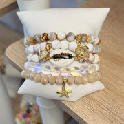 Love Lisa Coastal Sandbar bracelet stack displayed on pillow with ivory gemstone beads iridescent crystals and gold coastal charms