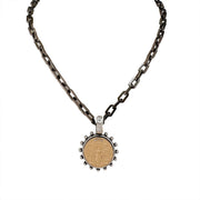 A gunmetal link chain necklace with a circular bee coin pendant in gold.