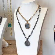 Necklace with chain design and pendant on a mannequin bust against a neutral background