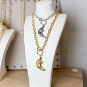 Necklace with moon and star charms on a white mannequin bust.