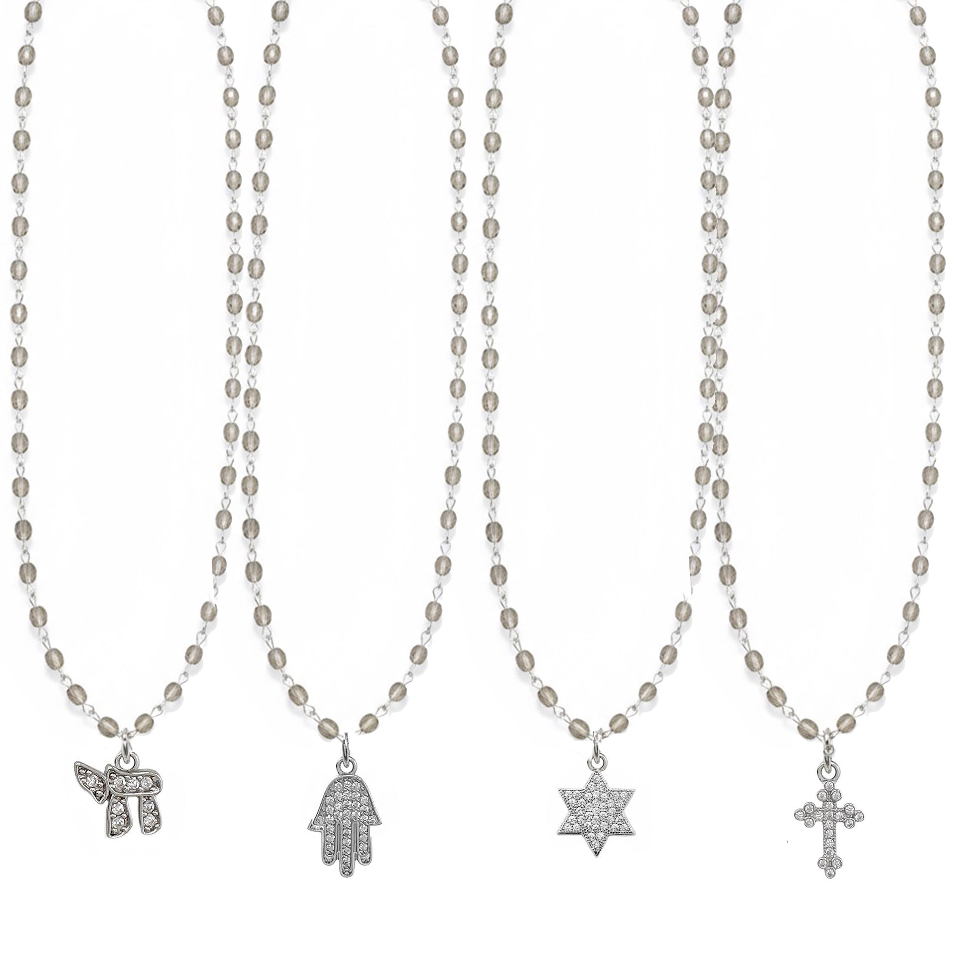 Set of four necklaces with various pendants on a white background