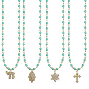 Turquoise beaded necklaces with gold charms on a white background