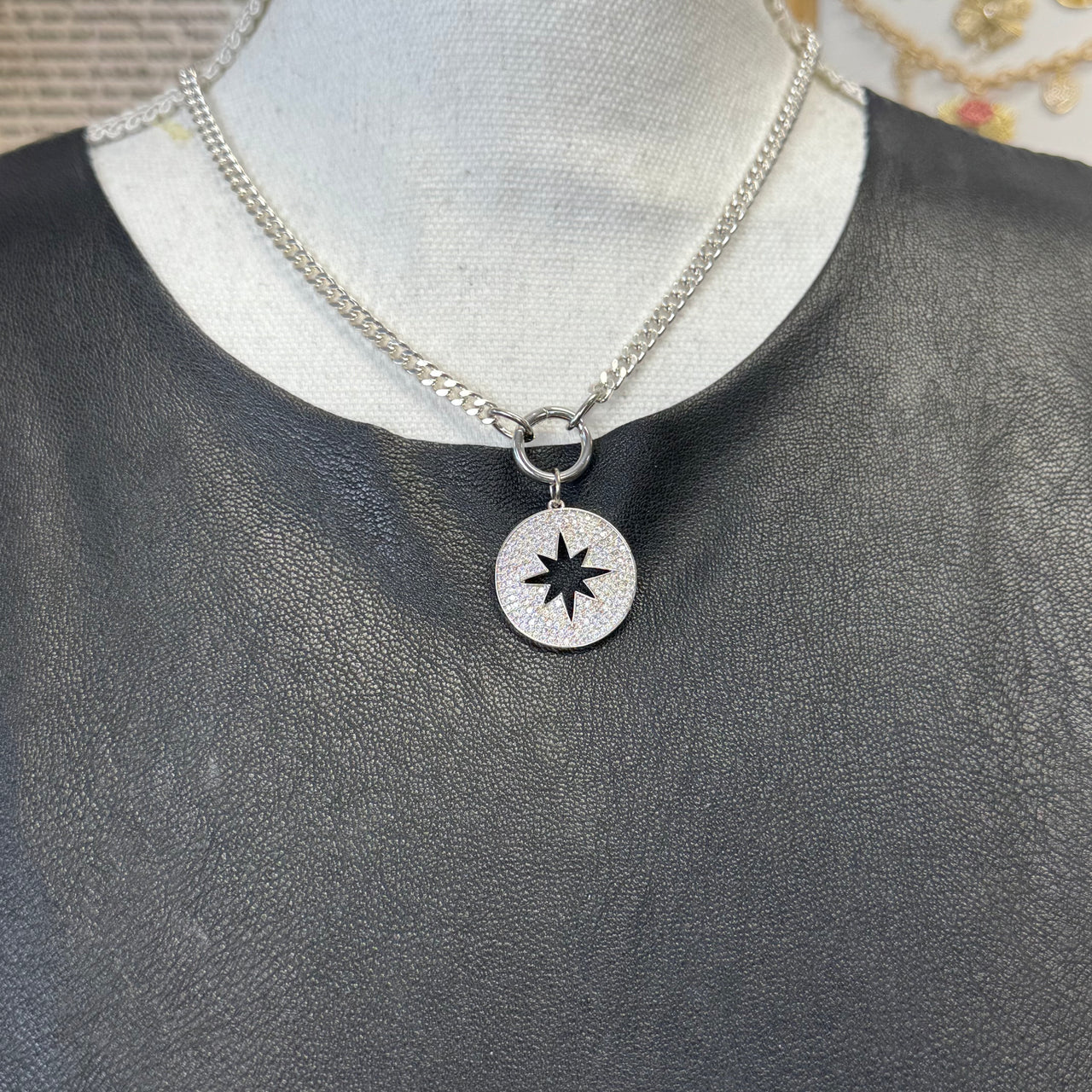 Silver starburst charm with open center and pavé crystals on display