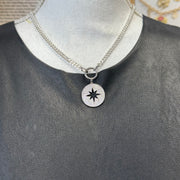 Silver starburst charm with open center and pavé crystals on display