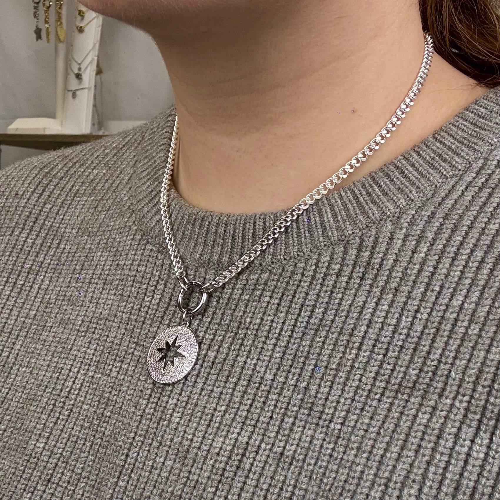 Round silver disc pendant with celestial star detailing