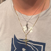 Two necklaces with pendants on a person wearing a gray shirt with a logo.