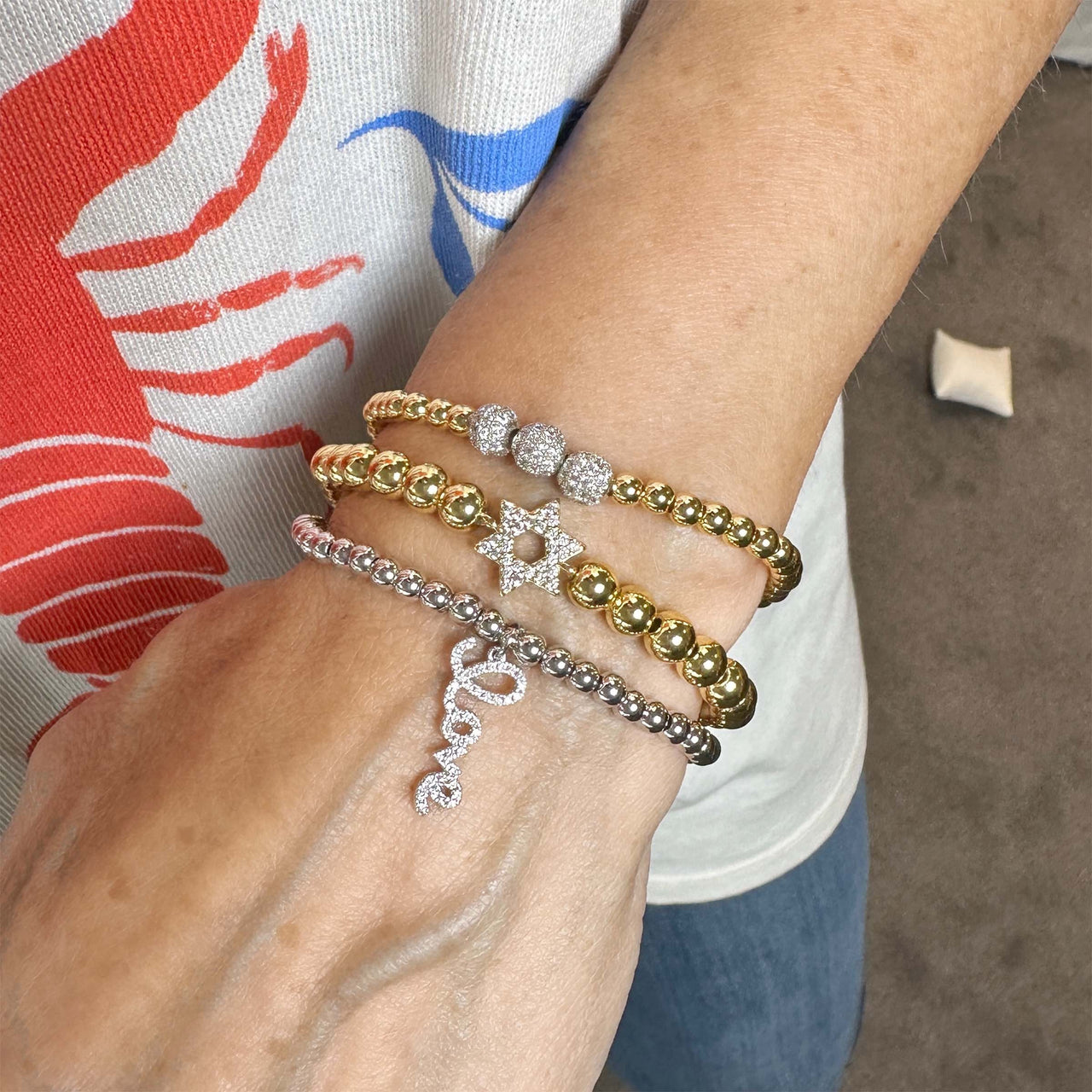 Close-up of a wrist wearing multiple bracelets with a blurred background