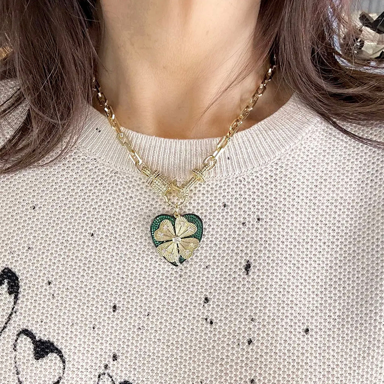 Love Lisa Elaine lucky clover heart necklace styled on model with bold chain and heart charm