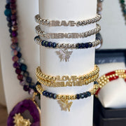 silver and gold empowerment butterfly bracelets stacked together love lisa jewelry