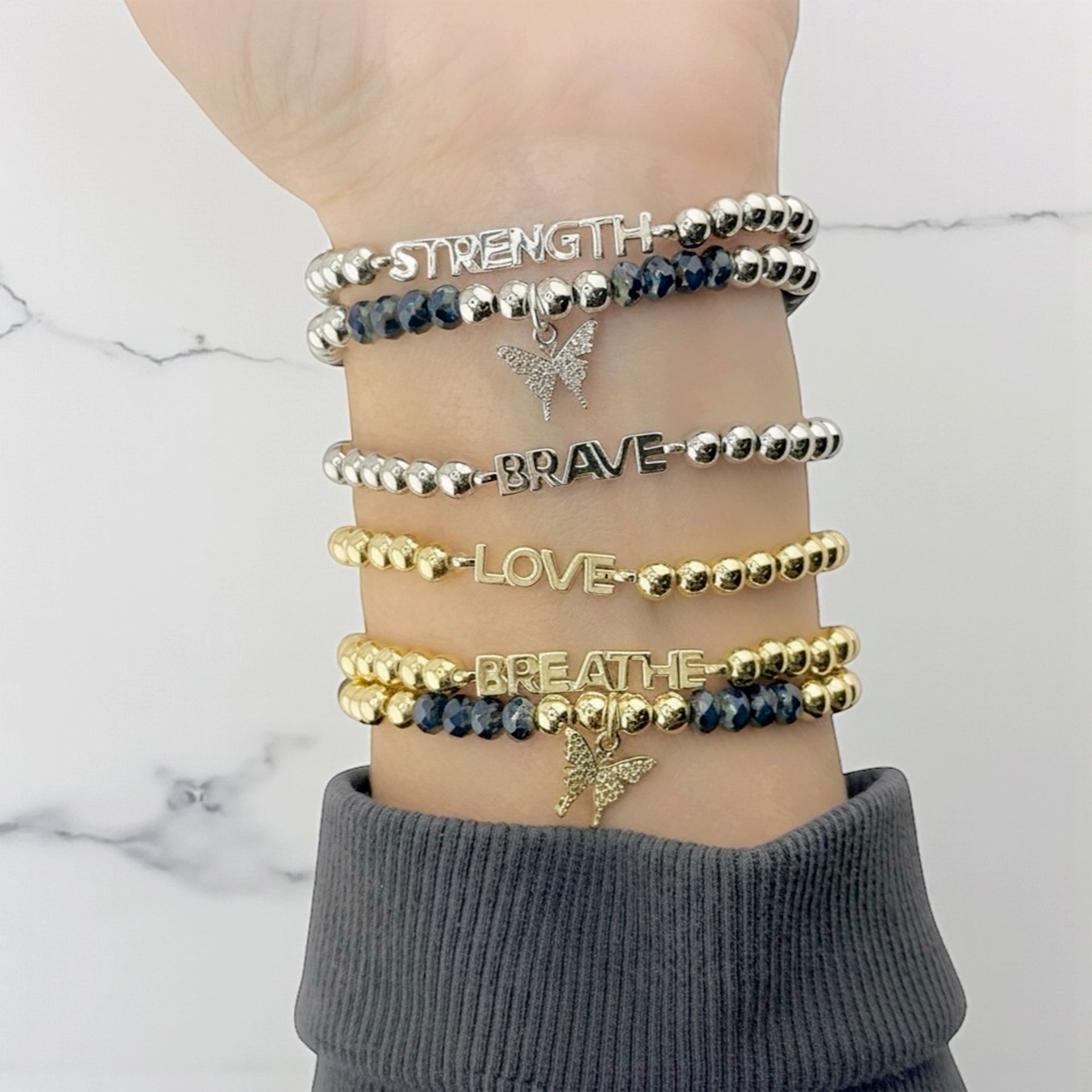 silver and gold empowerment butterfly bracelets stacked together love lisa jewelry