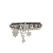 A stack of three bracelets featuring a mix of bead charms and pave charms, including a star, a chain, and a Hamsa hand symbol.