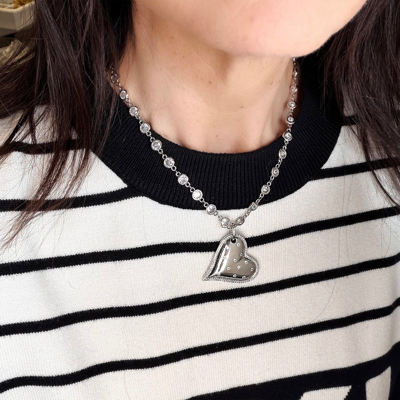 Love Lisa diamond heart necklace worn layered with striped top statement jewelry