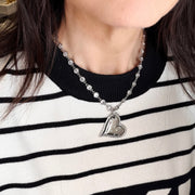 Love Lisa diamond heart necklace worn layered with striped top statement jewelry