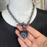Black-tone heart charm featuring a protective evil eye design display
