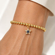 Love Lisa evil eye star bracelet worn on wrist delicate gold beaded bracelet