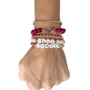 Love Lisa F★♥K CANCER breast cancer awareness bracelets worn in a layered pink and rose-gold wrist stack