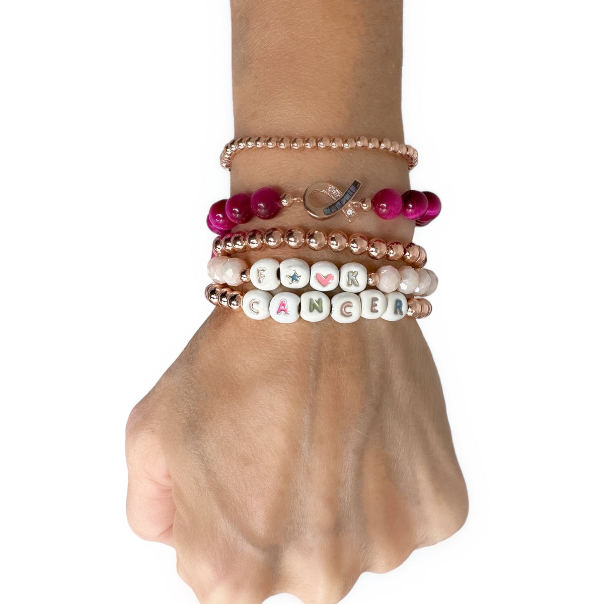 Love Lisa F★♥K CANCER breast cancer awareness bracelets worn in a layered pink and rose-gold wrist stack