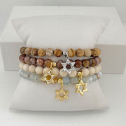 Stack of beaded bracelets with Star of David charms on a white surface