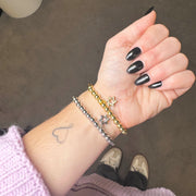 model wrist wearing the faith star of david bracelets in gold and silver